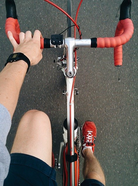 a hand reaches towards the handle bars of a bike